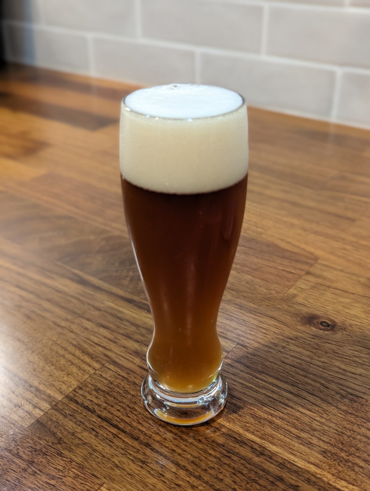 Photo of a small tasting glass containing amber ale