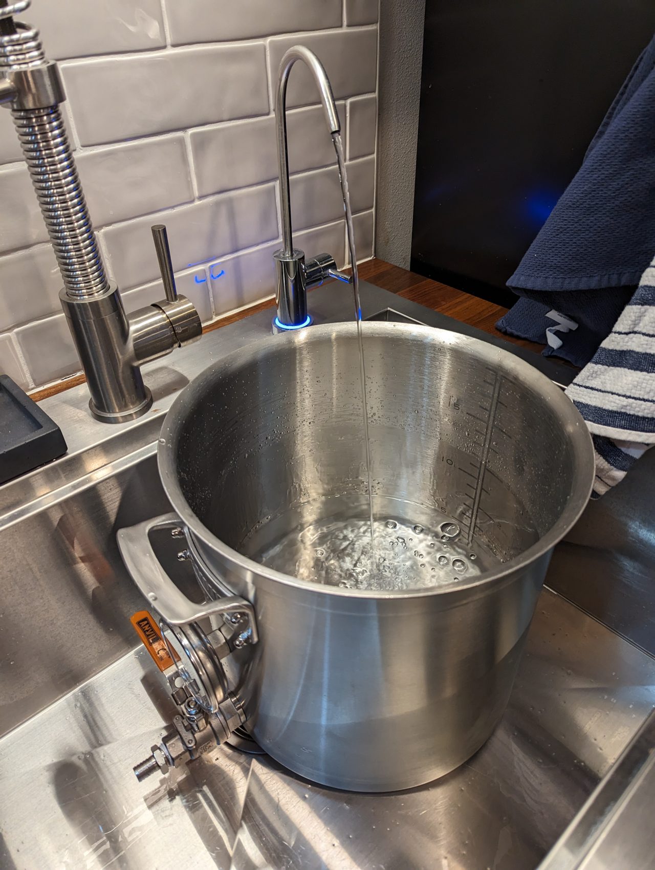 Photo of a 5-gallon stainless steel pot being filled with reverse osmosis water