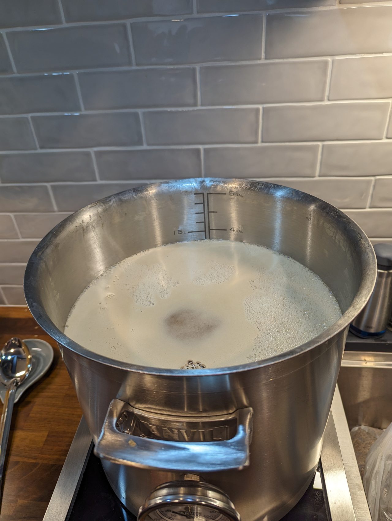 Photo of beer coming to a boil in a kettle with a lot of foam on top