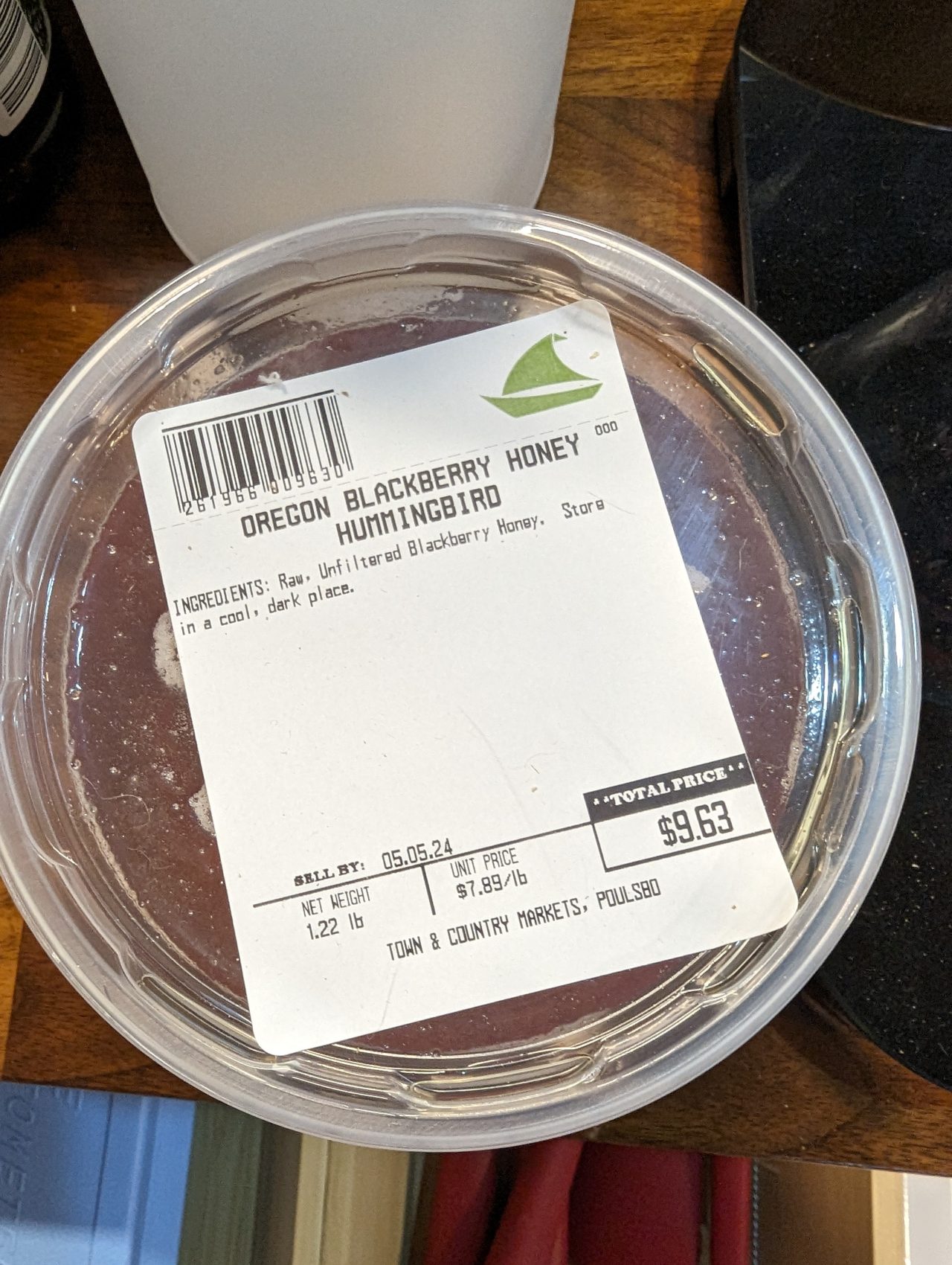 Photo of a small plastic container of blackberry honey