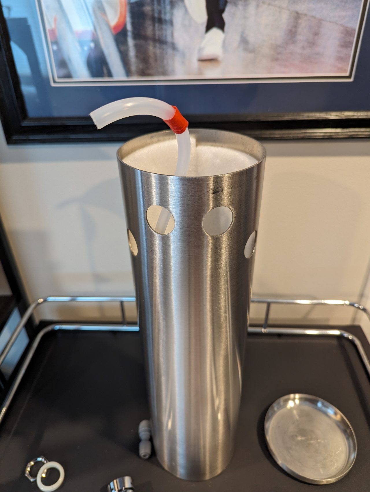 Photo of a beer line wrapped with a small piece of red masking tape protruding from the top of a stainless steel beer tower