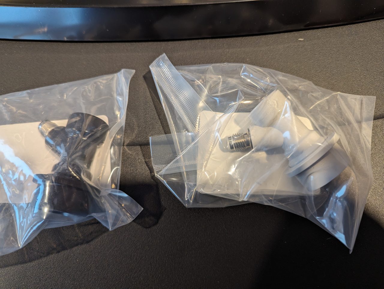 Photo of one black and one gray threaded ball lock disconnects