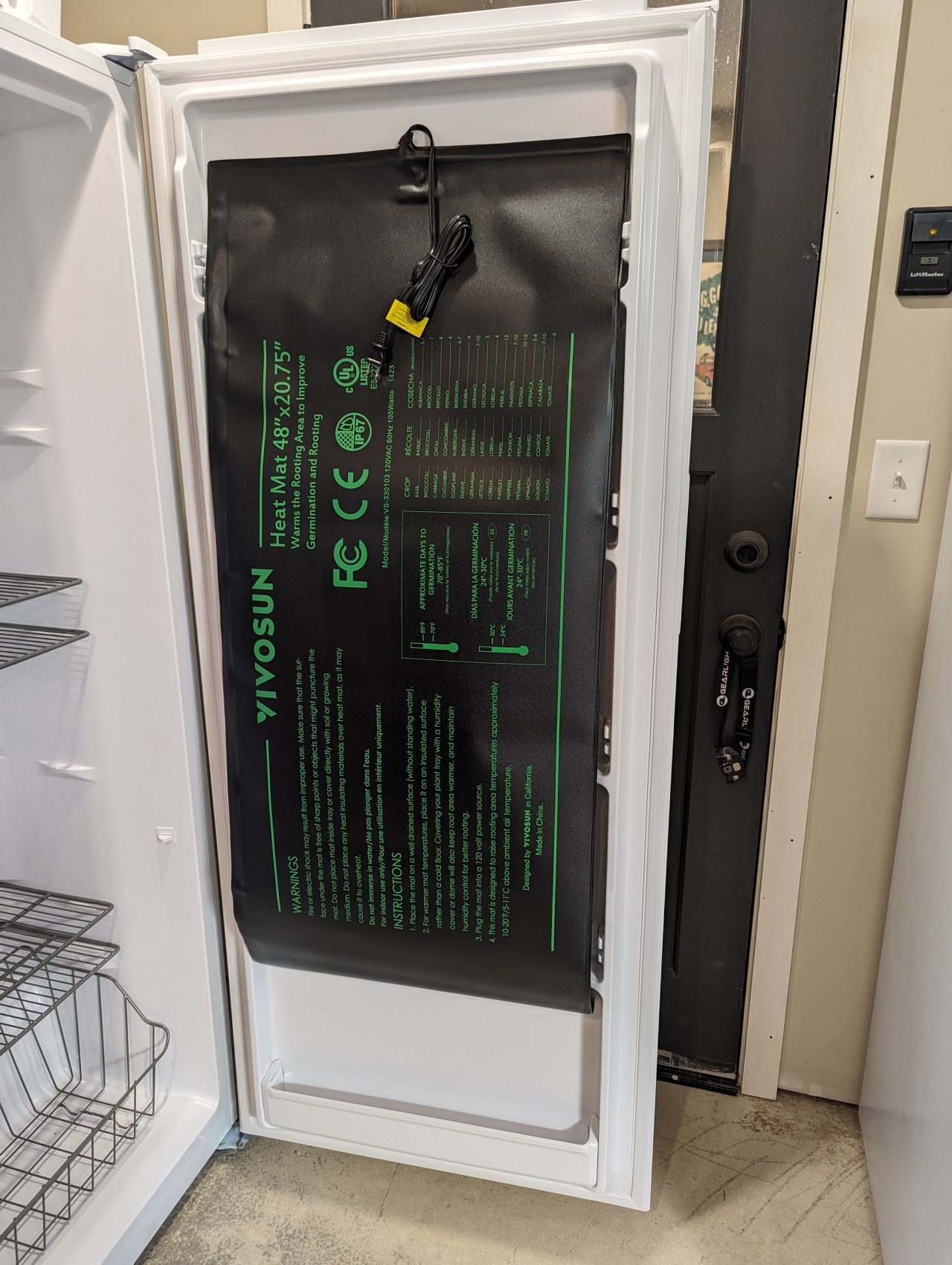 Photo of a 48" x 20.75" heating mat attached to the inside of an upright freezer door