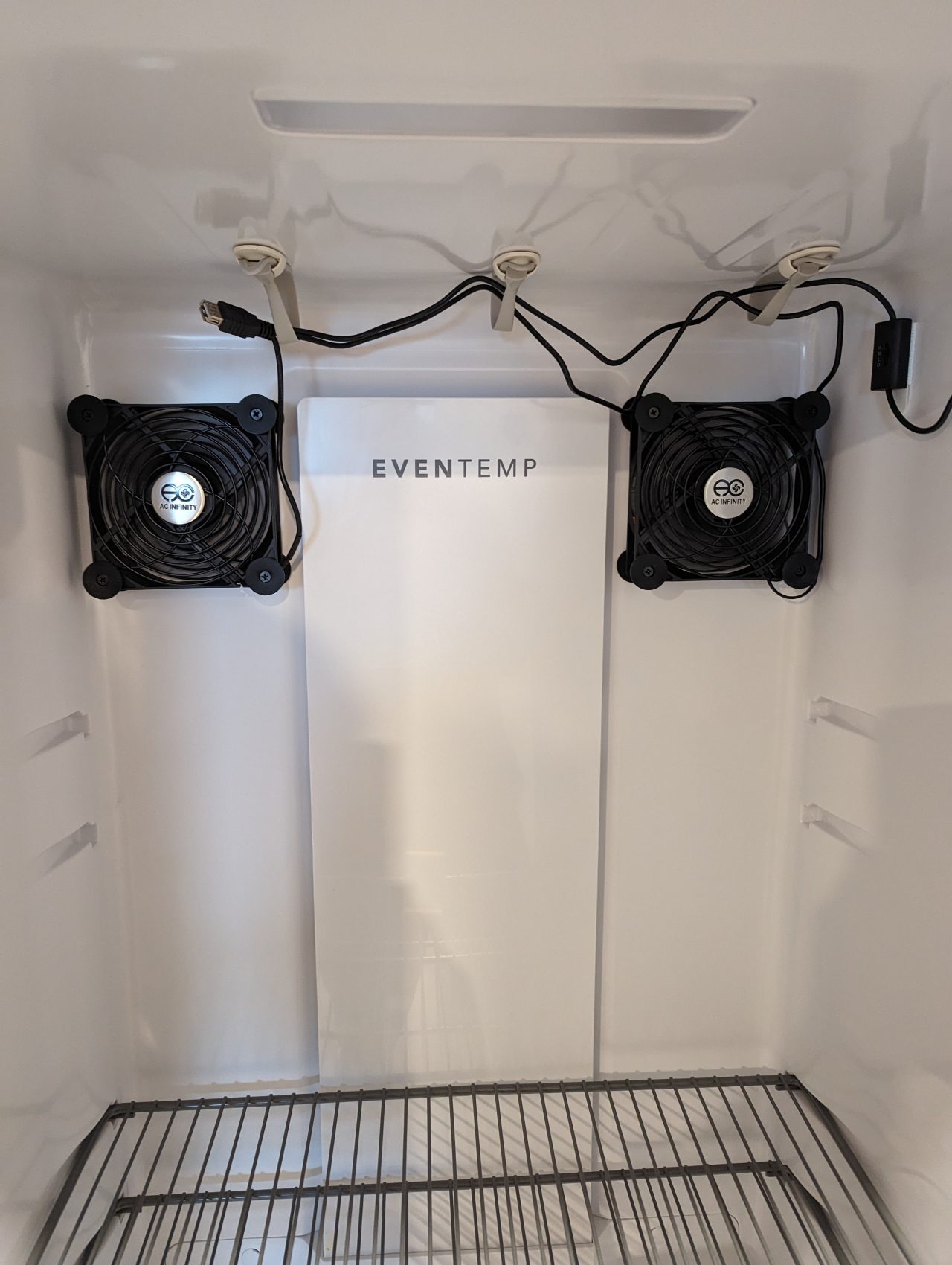 Photo of two 5" AC Infinity computer cooling fans mounted on the back wall of an upright freezer